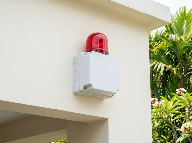 External burglar alarm siren and strobe unit mounted on the facade of a Singapore residential property