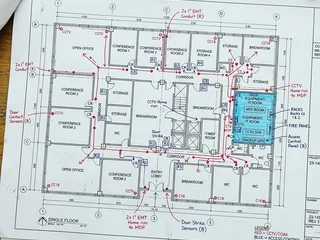 Architectural floor plan with security rough-in markings; conduit routes, equipment locations and power points identified on the drawing before construction begins