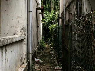 Dark unlit side passage between Singapore terrace houses; a typical blind spot that creates opportunity for unobserved approach