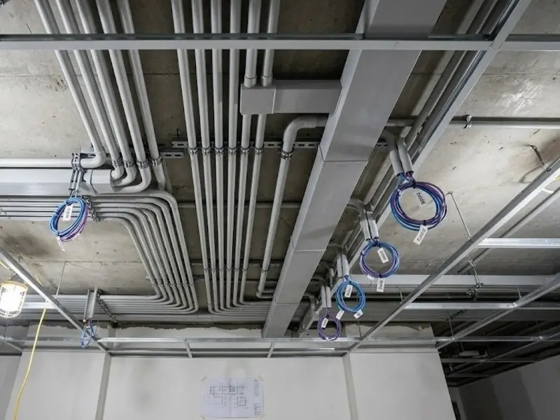 Multiple Cat 6 cables being pulled through wall conduit during renovation rough-in stage at a Singapore property